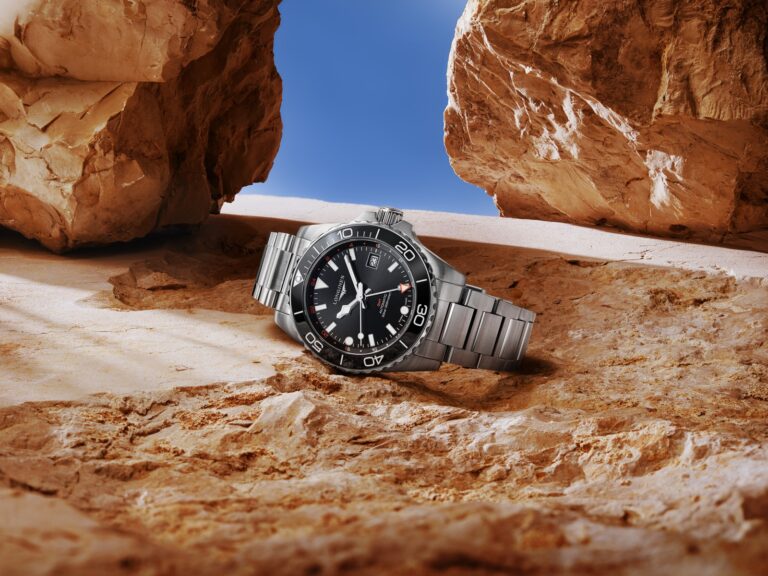 Longines HydroConquest dive watch on a steel bracelet, resting on desert rock